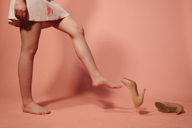 jambes de femme qui jettent ses chaussures au sol